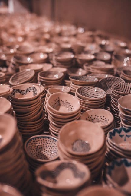Stacks of small handmade ceramic bowls in soft warm light